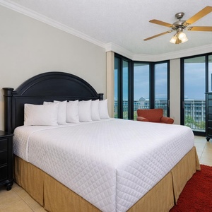 Guest bedroom featuring a plush king bed, cozy seating, and large windows with a lovely view