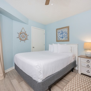 Bright and airy guest bedroom featuring a cozy double bed, twin bunk, nautical decor, and warm wood accents