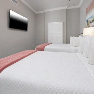 Drift to sleep on roomy queen beds beneath beach sand dune art, settle under the bedside lamp, and watch a movie