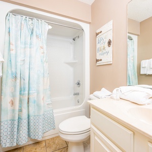 Refresh in this guest bath, surrounded by soft towels and coastal vibes, perfect for starting your beach day