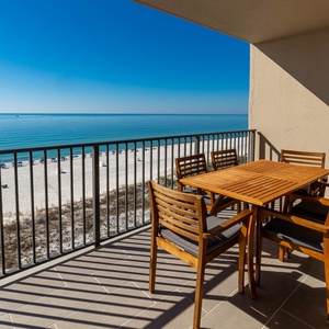 Dine at the outdoor table while enjoying expansive views of the calm water and beach below
