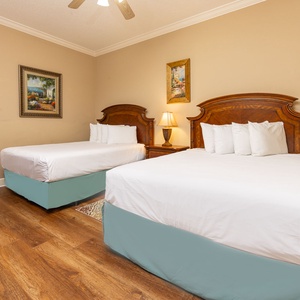 Drift into restful nights on soft, queen beds in this guest room, embraced by warm decor