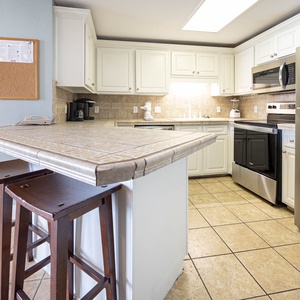 Prepare meals in the functional kitchen featuring stainless steel appliances and a convenient coffee corner with a Keurig