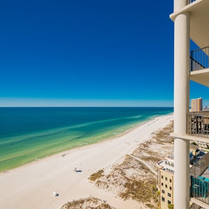 This stunning beach balcony offers a perfect spot to relax with turquoise chairs and a dining table overlooking the water