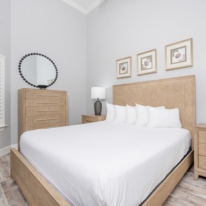 Inviting guest bedroom featuring a king bed, stylish wooden furniture, and elegant decor for a restful retreat