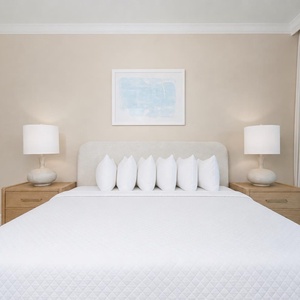 Spacious master suite featuring a king bed, fluffy pillows, and beachfront balcony access