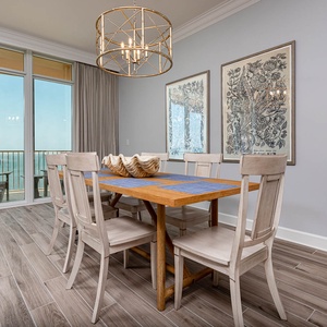 Sit at the dining table beneath the chandelier and gaze through glass doors to the calm coast