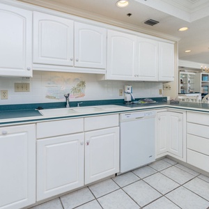 Bright and stylish open kitchen design featuring ample counter space, white cabinetry, and a charming view