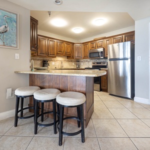 Enjoy casual meals at the breakfast bar, surrounded by warm wood tones and a stylish kitchen