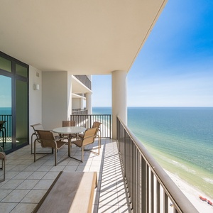 Relax on the spacious balcony with panoramic views of the sparkling waters and beach below