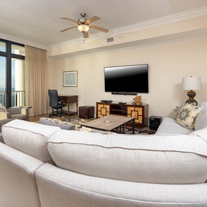 This inviting living area features a large TV, comfortable seating, and stunning views through expansive windows