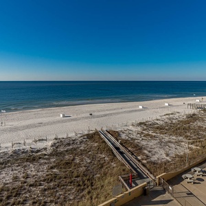 Expansive beachfront view showcases soft white sand and tranquil waters, inviting relaxation and seaside enjoyment