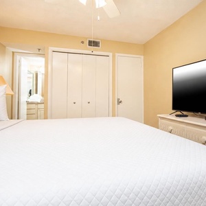 The inviting guest bedroom features a plush king bed, a flat-screen TV, and a light color palette