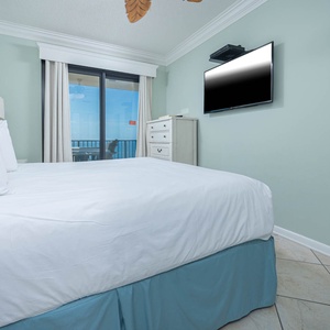 Relax in the comfortable master bedroom with a large king bed, coastal decor, and a beachfront view