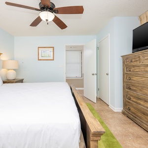 Inviting guest bedroom features a king bed and a mounted TV with an en-suite bathroom for a convenient guest experience