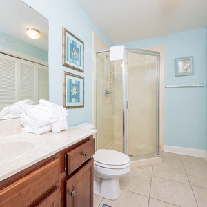 Additional bath featuring a walk-in shower, fresh towels, laundry area with washer/dryer, and coastal decor in soothing tones