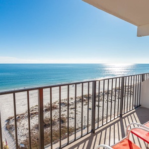 Enjoy breathtaking views from the balcony with comfortable seating overlooking the sandy beach and tranquil waters