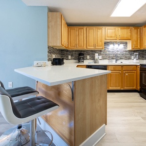 Prepare meals and gather around the kitchen featuring a sleek design with black appliances