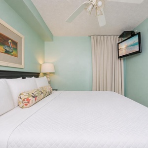 Fluffy pillows invite you to relax in the king suite for a calm movie night after a fun day at the beach