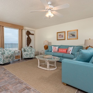 Relax in the inviting living area with comfortable seating, queen sleeper sofa, coastal decor, and a beachfront view