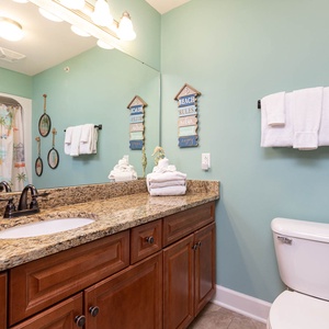This guest bathroom features a stylish granite countertop, colorful decor, and fresh towels for a relaxing stay