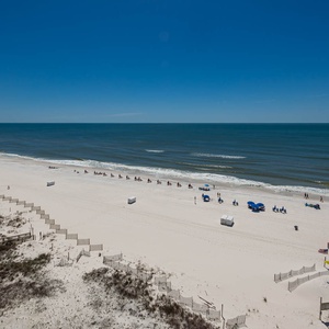 Gaze at the beachline dotted with beach chairs and umbrellas, inviting you to relax under the sun