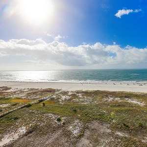 Expansive beachfront view showcasing the tranquil gulf waters and white sand, inviting relaxation and seaside adventures