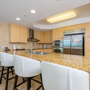Sleek and modern kitchen featuring sleek stainless appliances and a spacious granite countertop with stylish seating