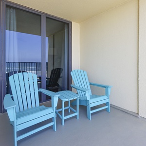 Relax in vibrant turquoise chairs on the balcony, perfect for enjoying the refreshing coastal breeze and beautiful views
