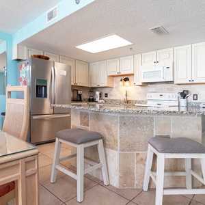 Kitchen area featuring granite countertops, a breakfast bar, and modern appliances for a delightful cooking experience