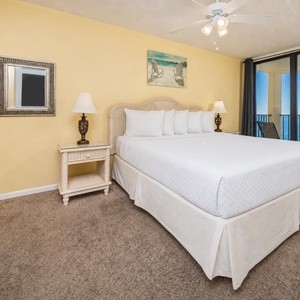 Master bedroom featuring a plush king bed and a private balcony with breathtaking coastal views