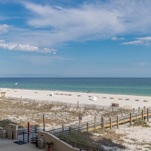 White sand beach stretches out under a clear blue sky, inviting relaxation and enjoyment by the water