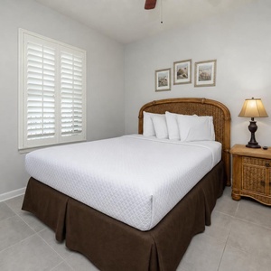 Rest in the guest bedroom, featuring a plush queen bed, stylish decor, and natural light from the window