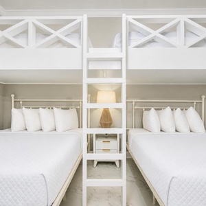 Cozy bunk room featuring two queen beds, a cozy loft area with two twins, and stylish lighting