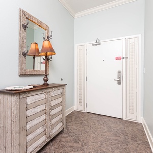 Charming entryway featuring a rustic console table, warm lamps, and a stylish mirror against soft blue walls