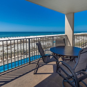 Enjoy meals or relax on the spacious balcony with comfortable seating and beautiful views of the beach