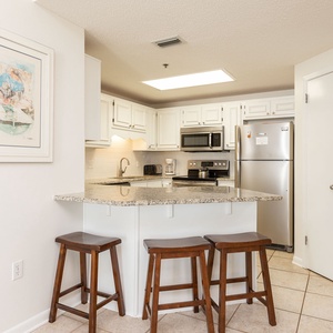 White cabinetry complements the granite countertops and stainless appliances in this inviting kitchen area