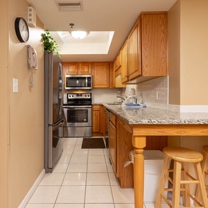 Inviting kitchen featuring stainless appliances, granite countertops, and cozy bar stools for casual dining