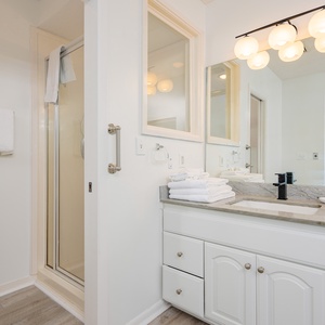 Master bath featuring a sleek walk-in shower and a stunning view of the coastline through large windows