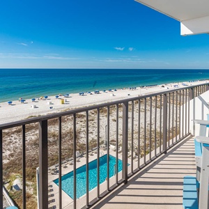 Enjoy stunning beachfront views from the balcony with comfortable seating and a glimpse of the inviting pool below