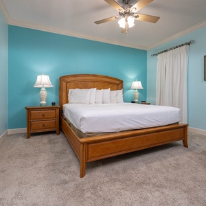 Serene master bedroom featuring a plush king bed, soft carpet, and calming blue walls for restful nights