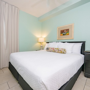 Unwind in the serene bedroom featuring a king bed, soft lighting, and coastal decor for a restful stay
