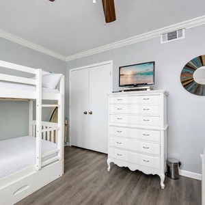 Twin over twin bunks in the guest room invite restful nights and TV time after a day along the shore