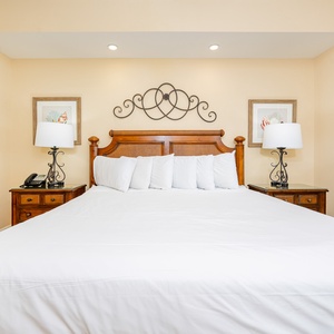 Cozy master bedroom featuring a king-size bed, elegant wooden furniture, and soft lighting for a relaxing retreat