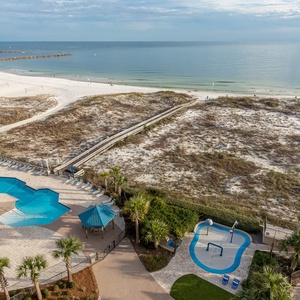 Relax by the inviting pool area surrounded by lounge chairs, with easy access to the beach and scenic views