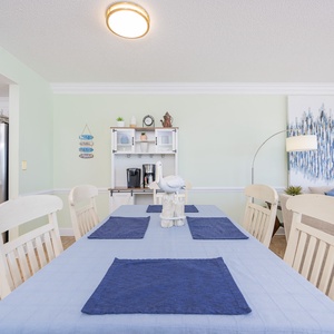 Dine at the spacious table, surrounded by coastal decor and a welcoming atmosphere perfect for gatherings