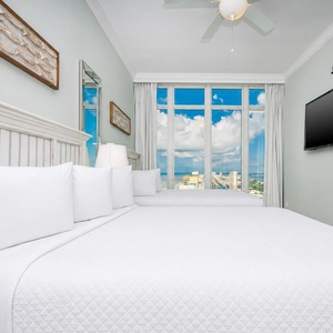 Experience comfort in this guest bedroom with two queen beds, stunning beach views, and coastal decor