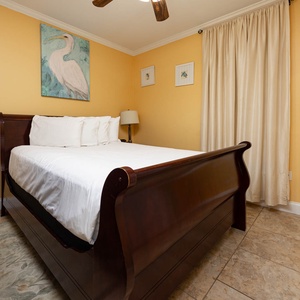 Unwind in this inviting guest bedroom featuring a queen bed, soft decor, and charming artwork on the walls