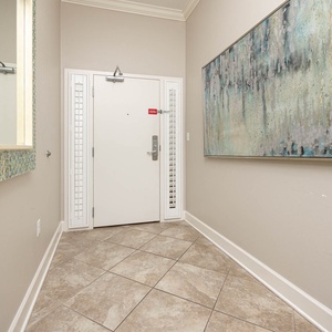 This welcoming entryway features elegant tile flooring and a stylish mirror, setting a serene tone for your stay