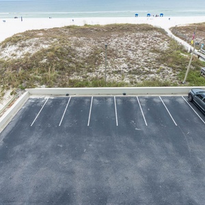 Enjoy easy beach access from third-floor property, with soft white sands and vibrant umbrellas just steps away